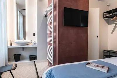 a bedroom with a bed and a bathroom with a sink at Charming Studio Retreat for Two in Central Ghent in Ghent