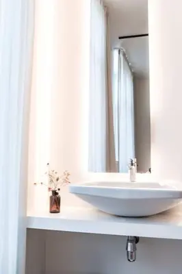 a bathroom with a white sink and a mirror at Charming Studio Retreat for Two in Central Ghent in Ghent