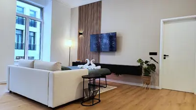 a living room with a white couch and a table at Le Cocon Studio in Brussels