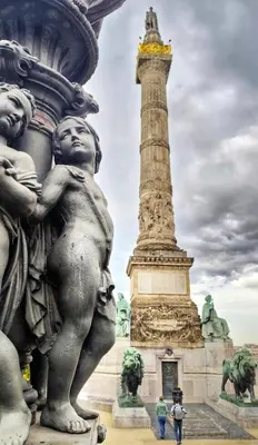 a statue of two children hugging a column in front of a monument at Le Cocon Studio in Brussels