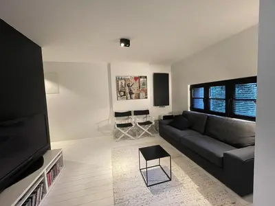 a living room with a couch and a flat screen tv at Appartement à proximité de Bruxelles in Meise