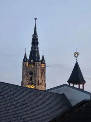 a clock tower is seen behind the roofs of a building at 8z dreamz 4 in Ghent
