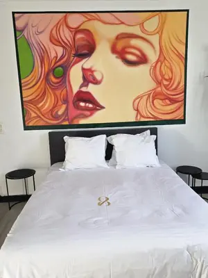 a bedroom with a bed with a large painting on the wall at 8z dreamz 4 in Ghent