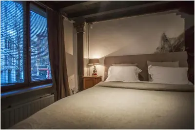 a bedroom with a large bed and a window at Living History - Drie Koningen in Antwerp
