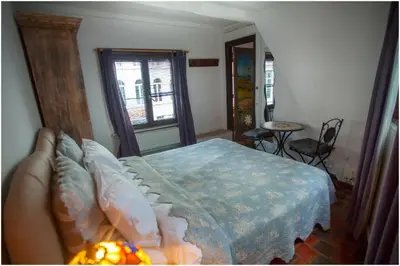 a bedroom with a bed and a table and a window at Living History - Drie Koningen in Antwerp