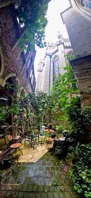 a patio with tables and chairs and a building at Living History - Drie Koningen in Antwerp