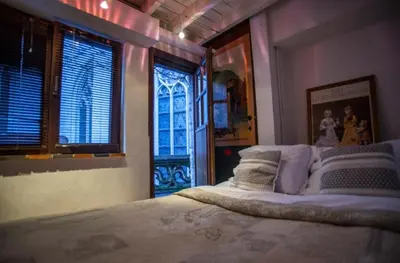 a bedroom with a large bed with pillows and windows at Living History - Drie Koningen in Antwerp