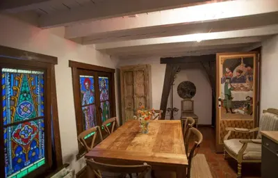 a dining room with a wooden table and stained glass windows at Living History - Drie Koningen in Antwerp