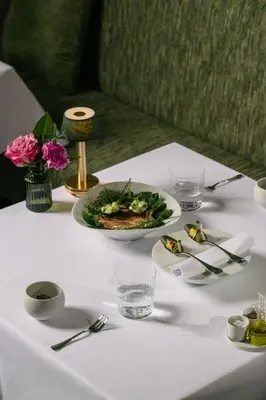 a white table with a plate of food on it at Boutique hotel-restaurant De Lindehoeve in Tessenderlo