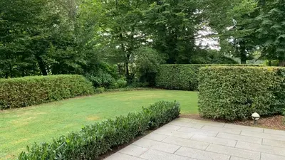 a garden with hedges and a walkway at Boutique hotel-restaurant De Lindehoeve in Tessenderlo