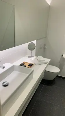 a bathroom with a white sink and a toilet at Boutique hotel-restaurant De Lindehoeve in Tessenderlo