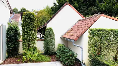 a white house with a red roof and ivy at Boutique hotel-restaurant De Lindehoeve in Tessenderlo