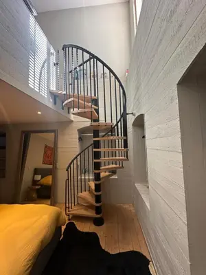 a spiral staircase in a room with a bed at Beautiful luxurious 1 bedroom apartment in the heart of the European Quarter in Brussels