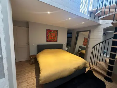 a small bedroom with a bed and a staircase at Beautiful luxurious 1 bedroom apartment in the heart of the European Quarter in Brussels