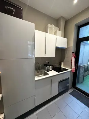 a kitchen with white cabinets and a sink at Beautiful luxurious 1 bedroom apartment in the heart of the European Quarter in Brussels
