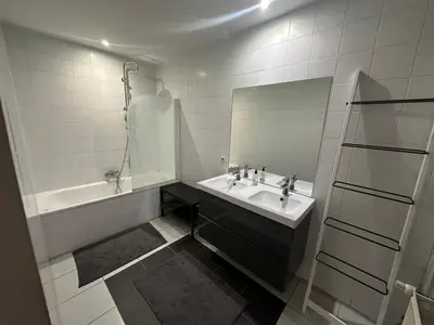 a bathroom with a sink and a mirror and a tub at Beautiful luxurious 1 bedroom apartment in the heart of the European Quarter in Brussels