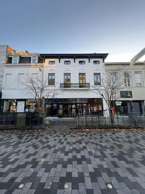 a large white building in a city with trees in front at Spacious, newly renovated loft - 107m2 in Sint-Niklaas