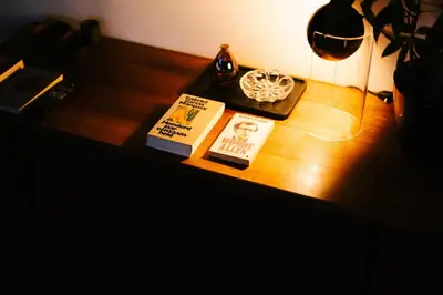 a table with two books and a lamp on it at A Place Antwerp - Boutique Suites & Flats - Leeuwenstraat 20 in Antwerp