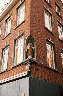 a statue on the side of a brick building at A Place Antwerp - Boutique Suites & Flats - Leeuwenstraat 20 in Antwerp