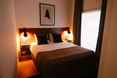 a bedroom with a bed with two pillows and a window at A Place Antwerp - Boutique Suites & Flats - Leeuwenstraat 20 in Antwerp