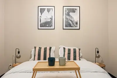a bedroom with a bed with a wooden table on it at Mubi-Stay - Appartement chalereux au centre ville D'Anvers in Antwerp