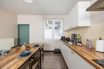 a kitchen with a table with blue plates on it at Mubi-Stay - Appartement chalereux au centre ville D'Anvers in Antwerp