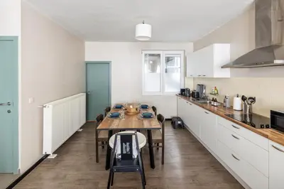 a kitchen with a table and chairs in a room at Mubi-Stay - Appartement chalereux au centre ville D'Anvers in Antwerp