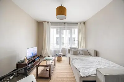 a living room with a bed and a tv at Mubi-Stay - Appartement chalereux au centre ville D'Anvers in Antwerp