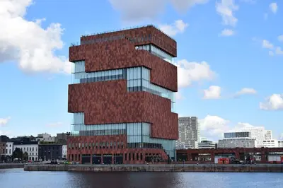 a tall red brick building next to a body of water at Mubi-Stay - Appartement chalereux au centre ville D'Anvers in Antwerp