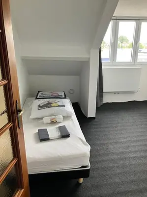 a small room with two beds and a window at Expats House 10 Stabroek Belgium in Stabroek