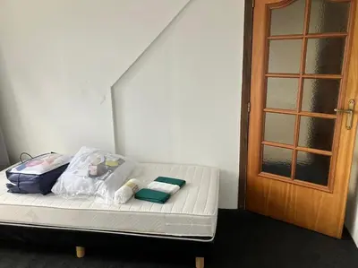 a bed in a room next to a door at Expats House 10 Stabroek Belgium in Stabroek