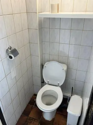 a small bathroom with a toilet and a trash can at Expats House 10 Stabroek Belgium in Stabroek