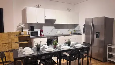 a kitchen with a table with chairs and a refrigerator at Simon Apartment in Antwerp