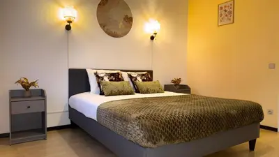 a bedroom with a bed and two lights on the wall at Simon Apartment in Antwerp