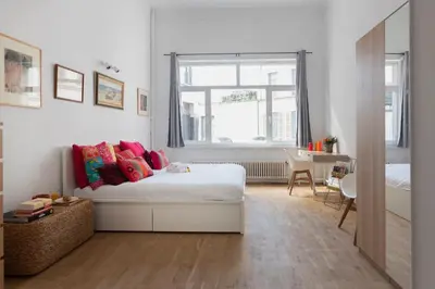 a bedroom with a bed with colorful pillows on it at Brussels Benit Ixelles House in Brussels