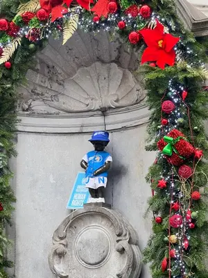 a statue of a police officer sitting on top of a monument at Manneken View in Brussels