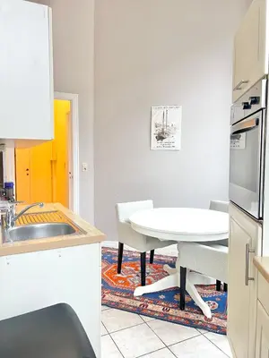 a kitchen with a white table and a table and chairs at Manneken View in Brussels