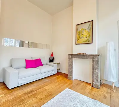a living room with a white couch and a fireplace at Manneken View in Brussels