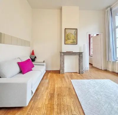 a living room with a white couch and a table at Manneken View in Brussels