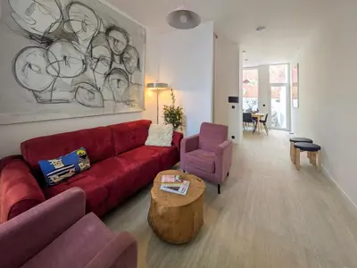 a living room with a red couch and a table at Guesthouse Josephine - Antwerpen in Antwerp