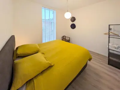 a large yellow bed in a room with a window at Guesthouse Josephine - Antwerpen in Antwerp