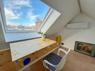 a room with a wooden table and a large window at Guesthouse Josephine - Antwerpen in Antwerp