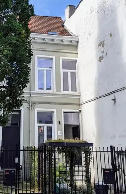 a white house with a fence in front of it at Guesthouse Josephine - Antwerpen in Antwerp