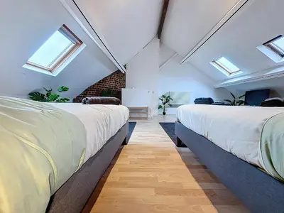 two beds in a room with skylights at Porte de Namur in Brussels