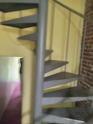 a spiral staircase in a room with a brick wall at FAMILY ROOM lux in Brussels