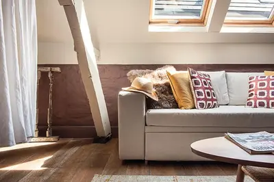 a couch with pillows on it in a living room at Ganda Rooms & Suites in Ghent