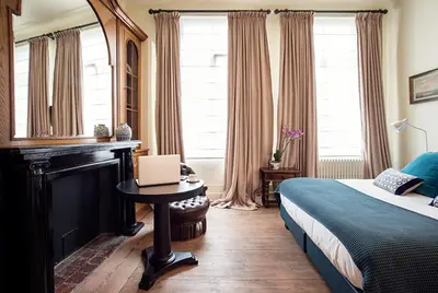 a bedroom with a bed and a laptop on a table at Ganda Rooms & Suites in Ghent