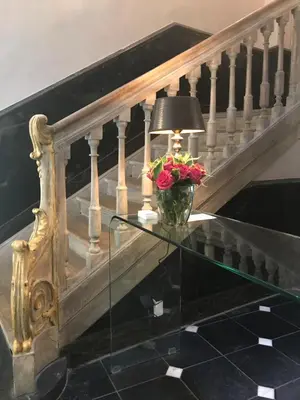 a vase of flowers on a glass table next to a staircase at Ganda Rooms & Suites in Ghent