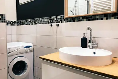 a bathroom with a sink and a washing machine at Renovated one bedroom apartment Schuman area in Brussels