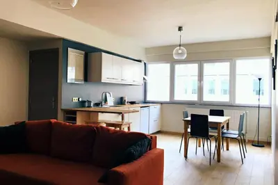 a living room and kitchen with a couch and a table at Renovated one bedroom apartment Schuman area in Brussels